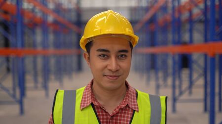 Warehouse worker posting in a large warehouse
