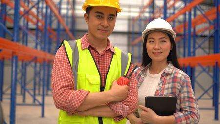 warehouse workers posing while working in distribution warehouse.