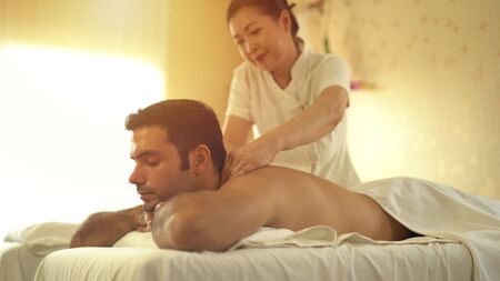 Young caucasian man relax during massage on backの写真素材