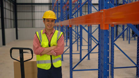 Warehouse worker posting in a large warehouse