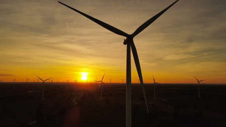 Beautiful sunset above the turbines on the field