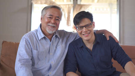 Portrait asian Father and his son looking at the camera at home