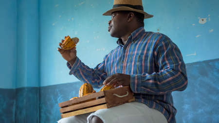 Portrait of a happy African American man carrying a box of fresh Cacao