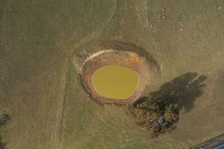 A dry livestock watering hole in the Australian outback due to the severe drought