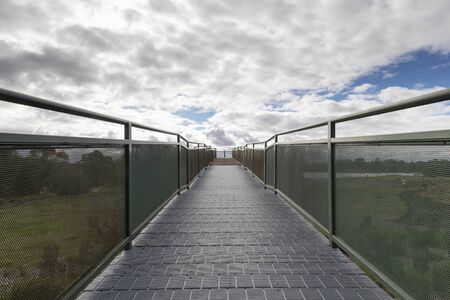 A walkway and viewing platform overlooking a lake in a community park.