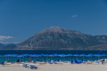 People relaxing on the beach under umbrellas in Patras in Greece.の写真素材