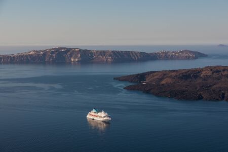 A cruise ship on the blue Aegean Sea near Santorini Island in the Greek Islandsの写真素材