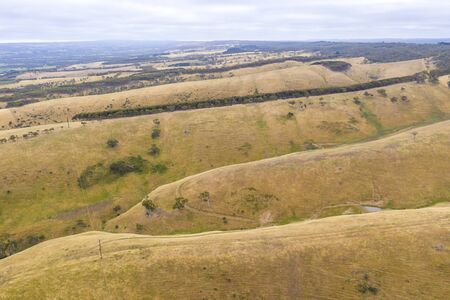 Rolling green hills and trees in farmland south of Adelaide in Australiaの写真素材