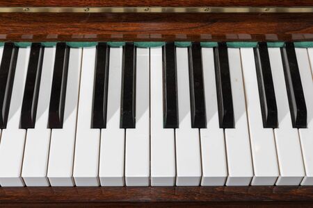 Old piano keys in brown textured woodの写真素材