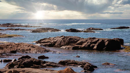 The brown Rocks and blue water of the Tasman Sea at Birubi Point near Port Stephens in regional New South Wales in Australiaの写真素材