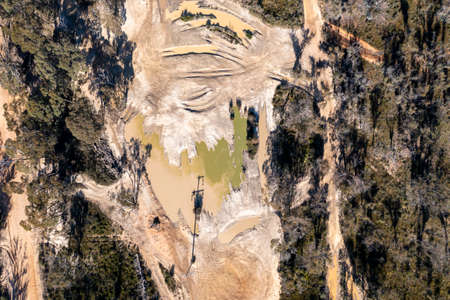 Drone aerial photograph of flood water on a dirt road in a forest in regional Australiaの写真素材