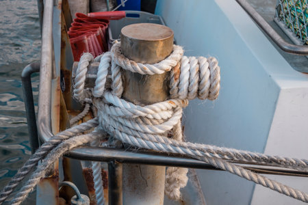 Photograph of white rope wrapped around a steel boat mooring bollard on King Island in the Bass Strait of Tasmania in Australiaの写真素材