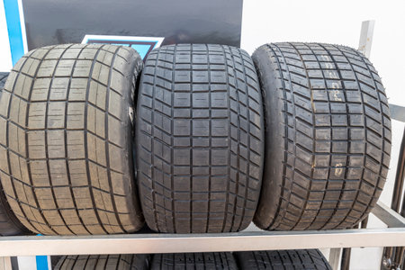 Photograph of the tread and pattern on large rubber speedway race car tyres in the pit area before...