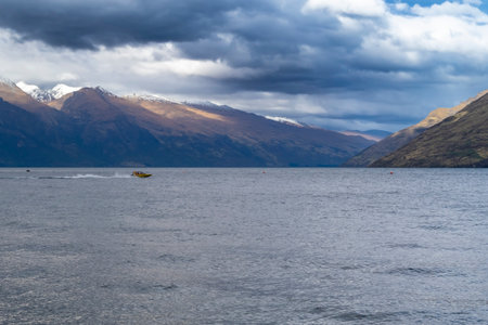 Photograph of Lake Wakatipu in Queenstown with mountains and clouds in the background on the South Island of New Zealandの写真素材