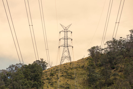 Photograph of a large electricity Transmission Tower on a grassy hill against an orange sunset sky in regional Australia.の写真素材