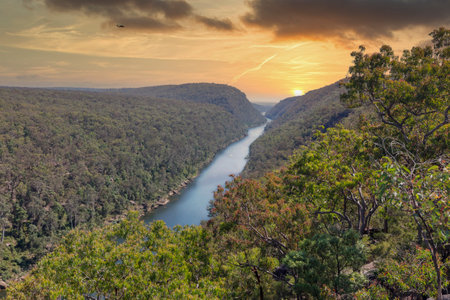 Photograph of the Nepean River under a cloudy orange sky from The Rock Lookout observation point in the Blue Mountains in New South Wales, Australia.の写真素材