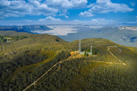 Drone aerial photograph of large communication towers on the ridge line of the picturesque and wide...