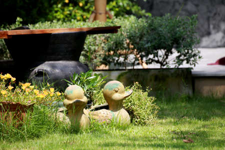 Duck statue put on field among flower plant with sunlight, Restaurant decoration and designの写真素材