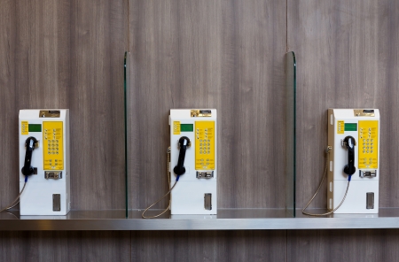 public telephone coin on wooden wall