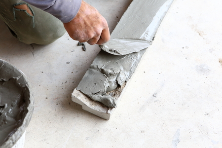 plasterer concrete worker at wall of house construction の写真素材