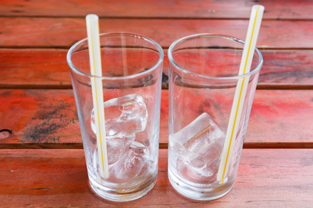 ice in glass on rad wooden tableの写真素材