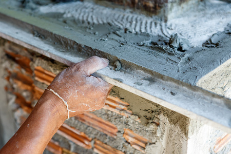 plasterer concrete worker at wall of house constructionの写真素材