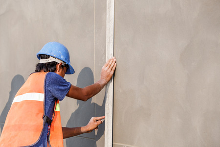 plasterer concrete worker at wall of house constructionの写真素材