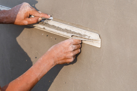 plasterer concrete worker at wall of house constructionの写真素材