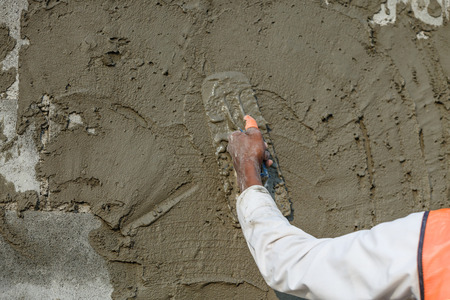 plasterer concrete worker at wall of house constructionの写真素材