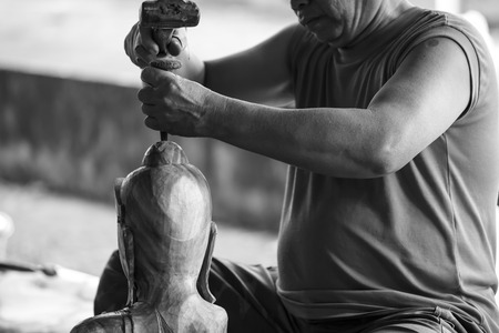 Hand of carver carving wood in blackand white color toneの写真素材