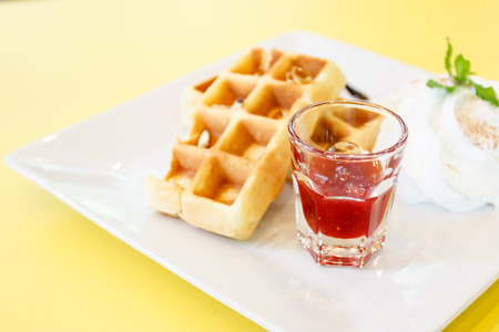 Strawberry Waffle whipped Cream on yellow deskの写真素材