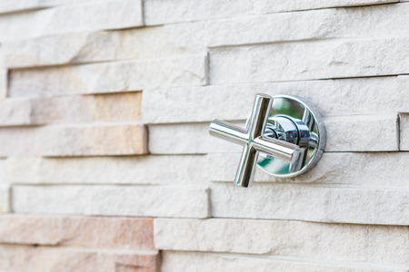 faucet steel on stone wallの写真素材