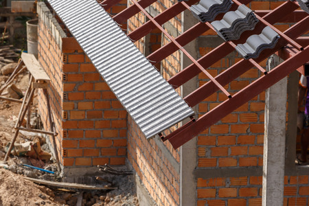 roof under construction with stacks of roof tiles for home building