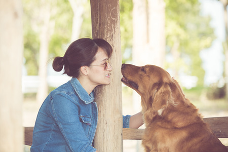 Beautiful woman with a cute golden retriever dogの写真素材