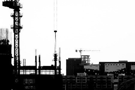 Construction site with cranes on silhouette backgroundの写真素材
