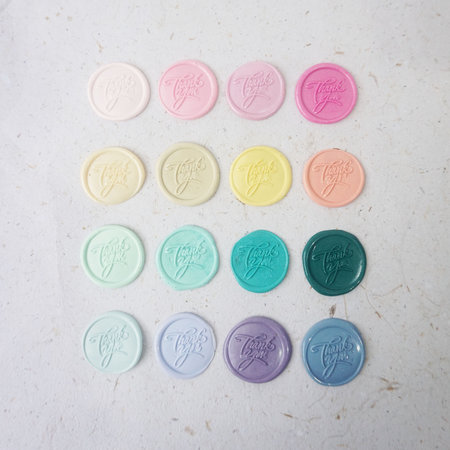 Colorful pretty wax seal stamps coin on white paper background, vintage style for wedding or invitation decoration. Top view. Flat lay. copy spaceの写真素材
