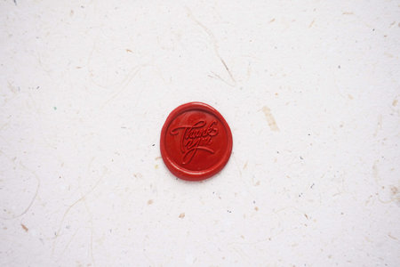 Red wax seal stamp on white paper background, closeup of photoの写真素材
