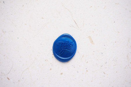 Close-up of a blue wax seal on a white background.の写真素材