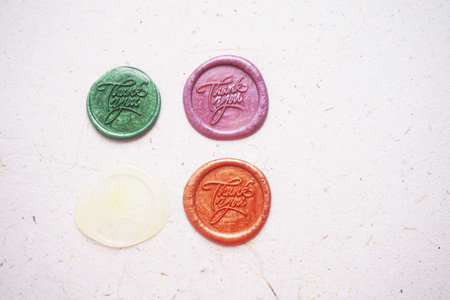 colorful thank you wax coin for vintage wedding invitation decoration on paper background,vintage color tone.の写真素材