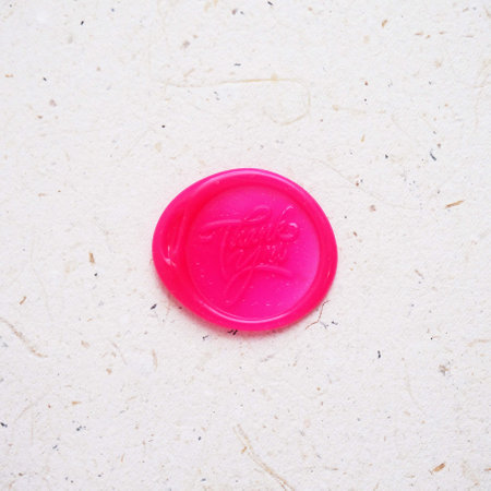 Pink plastic wax seal stamp on white paper background with copy space.の写真素材