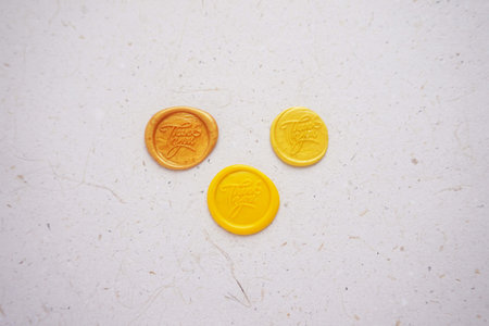Yellow and orange plastic coins on a white background. The concept of saving money.の写真素材