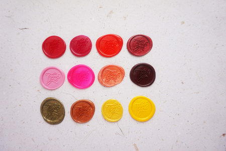Colorful wax seal stamps on white paper background, vintage style.の写真素材