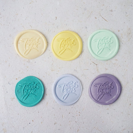 Colorful wax seal stamps on white paper background, close up.の写真素材