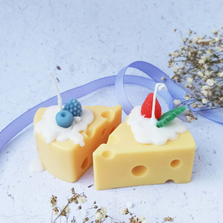Cheese cake candle with white cream and blue berries on a light backgroundの写真素材