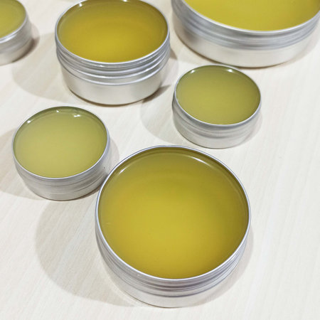 Cans with homemade balm on a table in a petri dishの写真素材