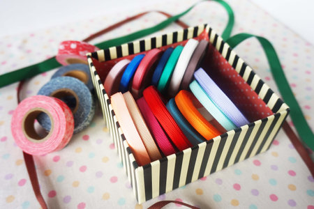 Colorful ribbons in a gift box on a polka dot backgroundの写真素材