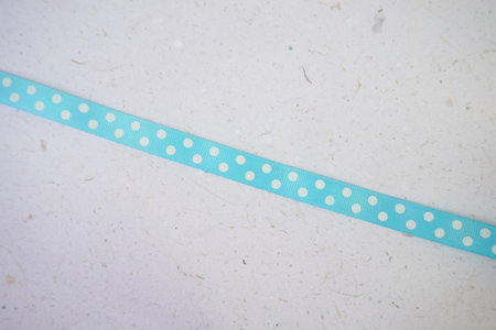 Blue polka dot ribbon on paper background, vintage color tone.の写真素材