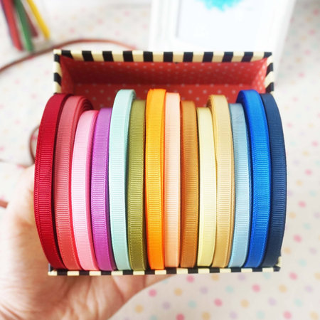 Colorful ribbons of different sizes in a box on the tableの写真素材