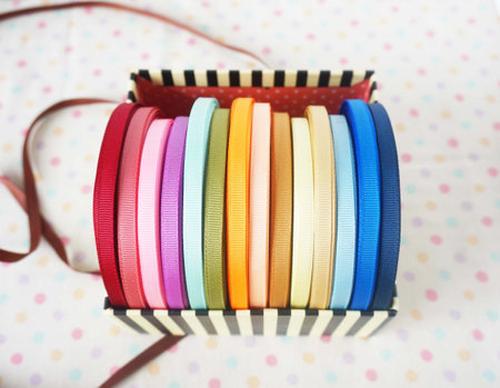 Stack of colorful ribbons on polka dot background, close upの写真素材