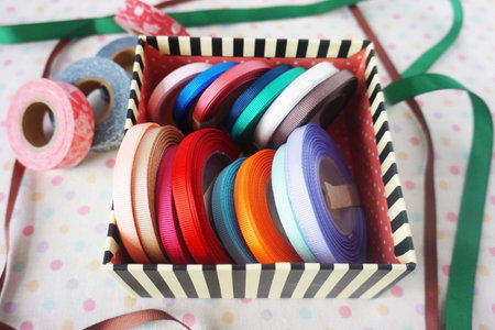 Colorful ribbons in box on tablecloth, close-upの写真素材